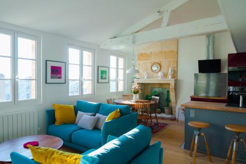 a living room with a blue couch and a table at La Loge du 12 in Bordeaux