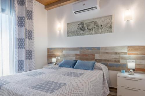 a bedroom with a bed with blue pillows at Casa Capricho in Vejer de la Frontera