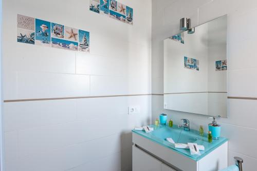 a bathroom with a blue sink and a mirror at Casa Capricho in Vejer de la Frontera