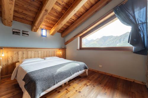 a bedroom with a bed and a large window at Civico 8 in Marmora