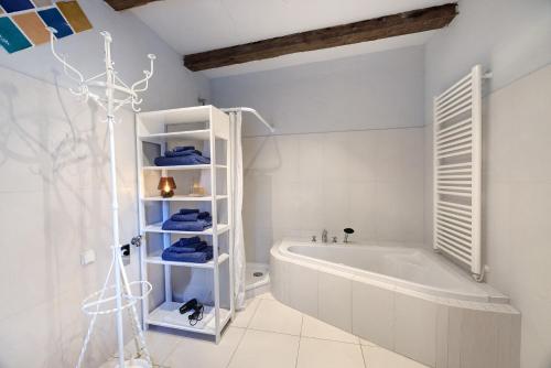 a white bathroom with a tub and a shower at Das Künstlerhaus - dein Sommerhaus in Köckern