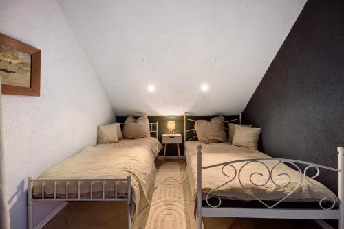 two twin beds in a room with a attic at Das Künstlerhaus - dein Sommerhaus in Köckern