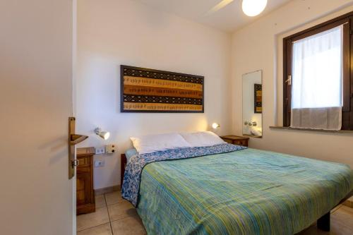 a bedroom with a bed and a window at Pergola 706 in Stintino