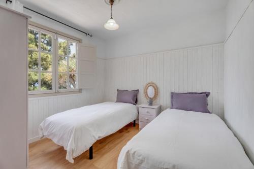 two beds in a room with two windows at Casa Juliana Tijarafe in Tijarafe