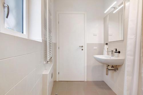 a white bathroom with a sink and a mirror at Workation Castle - Casa Galbiga in Carlazzo