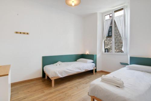 two beds in a room with two windows at Workation Castle - Casa Galbiga in Carlazzo