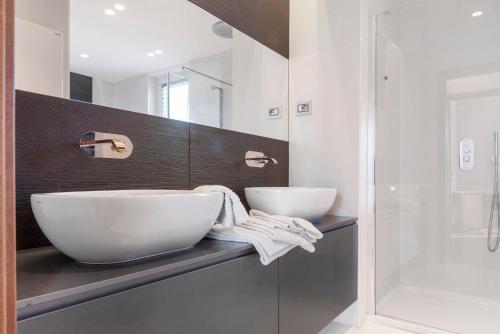 a bathroom with two sinks and a shower at Villa Luna Al Lago in Biandronno