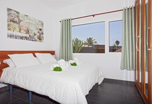 a bedroom with a bed and a large window at Villa Esencia in Puerto del Carmen