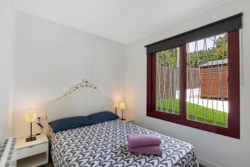 a bedroom with a bed and a large window at Casa-piscina privada en Vallpineda in Sant Pere de Ribes