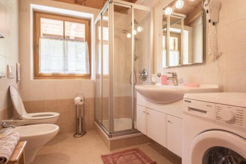 a bathroom with a toilet and a sink and a shower at Chalet Crepes De Sela in Canazei