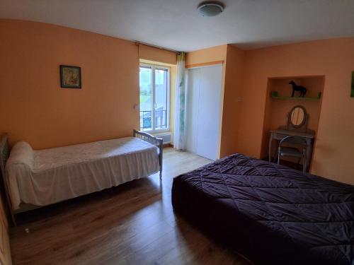 a bedroom with two beds and a window at Gîte De La Haie Bourgère in Moulay