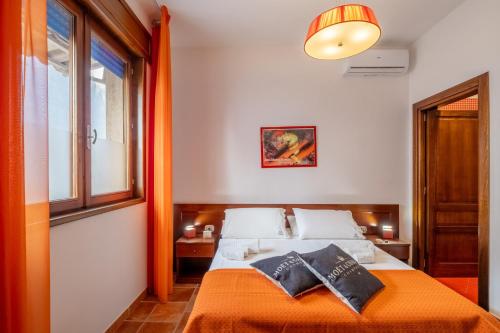 a bedroom with a bed with an orange blanket at By The Sea – Le Chele in Torre Lapillo