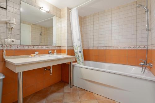 a bathroom with a sink and a tub and a mirror at Villa Private Pool Los Cristianos in Los Cristianos