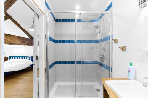 a bathroom with a shower with blue and white stripes at Gite La Ferme En Sud Charente in Montboyer