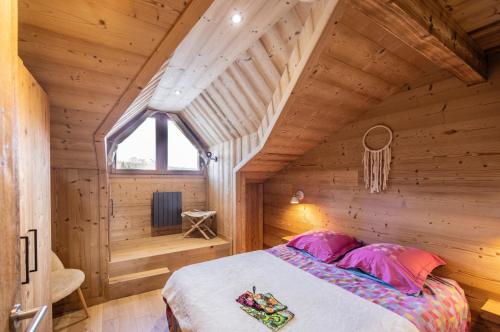 a bedroom in a log cabin with a bed at L'alpin in Les Déserts
