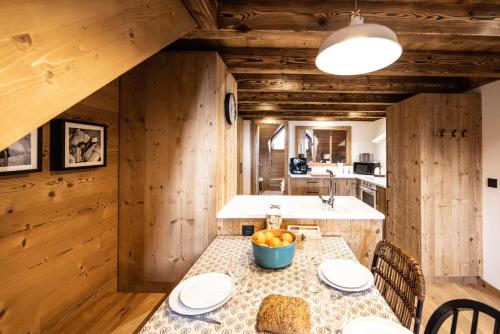 a kitchen with a table with a bowl of fruit on it at L'alpin in Les Déserts