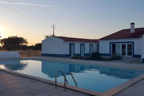a swimming pool in front of a house at Monte Azul, Um Oásis No Alentejo in Vimieiro