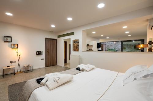 a bedroom with a large white bed with towels on it at The Apex Boutique Studio in Athens
