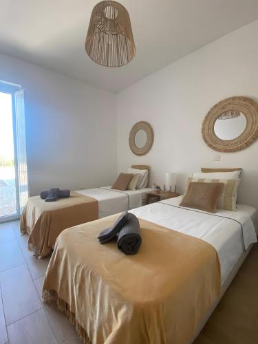 a room with three beds with a hat on top of them at Monte Azul, Um Oásis No Alentejo in Vimieiro