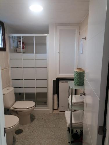 a white bathroom with a toilet and a shower at Apartamento Soraya in San Bartolomé
