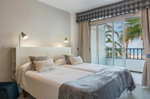 a bedroom with two beds and a large window at Apartamento Soraya in San Bartolomé