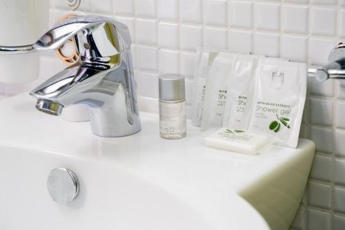a bathroom counter with a sink with products on it at By The Sea – Le Chele in Torre Lapillo