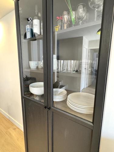 a cabinet filled with white plates and dishes at Chalet Mar Y Montaña in Los Silos