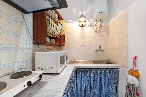 a kitchen with a microwave and a sink at Finca Lucrecia in Fasnia