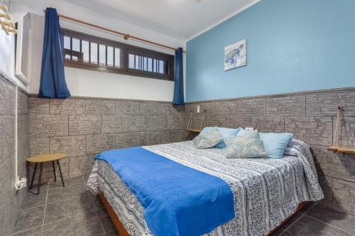 a bedroom with a bed with blue sheets and a window at Casa Lita in Antigua