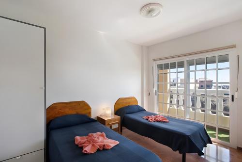 two beds in a room with a window at Casa del Pescador 2 in Santa Cruz de Tenerife