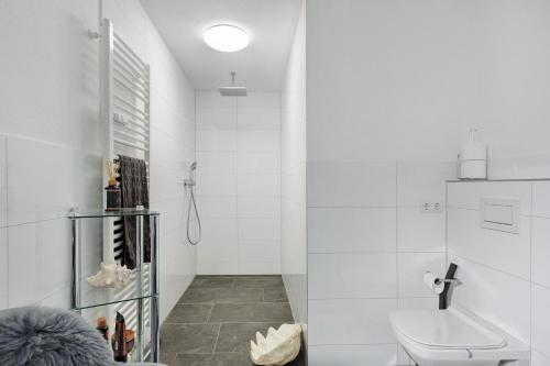 a white bathroom with a toilet and a sink at Deluxe Loft Hegau Bodensee in Hilzingen