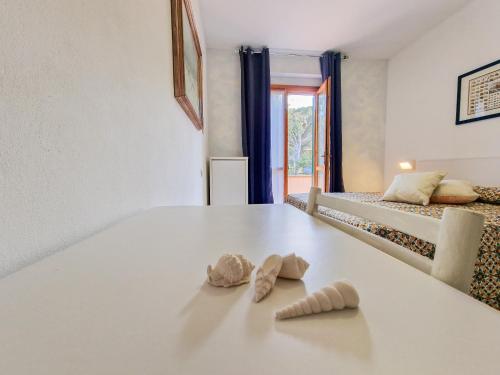 a room with two slippers on a table with two beds at Altaluna Apartment with Pool in Nisporto