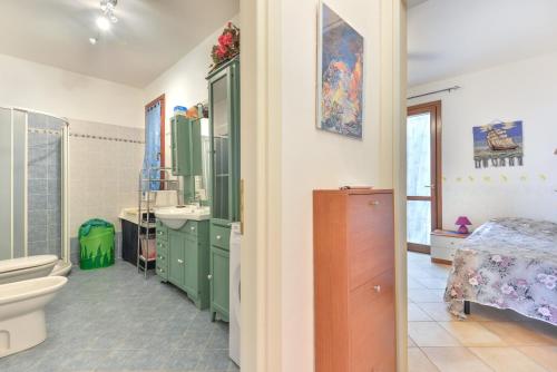 a bathroom with green cabinets and a sink and a toilet at Appartamento Orchidea in Capoliveri