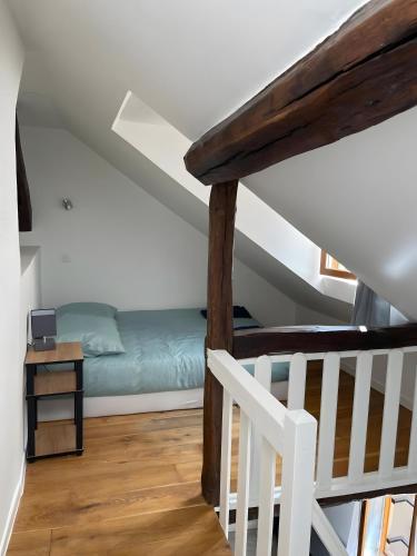 a room with a bed in the attic with a staircase at Logement Cosy centre Joigny C4 in Joigny