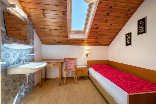 a bedroom with a bed and a sink and a window at Urthalerhof Historic in Valdaora