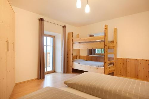 a bedroom with two bunk beds and a window at Rafaser - Apartment Albina in Feldthurns
