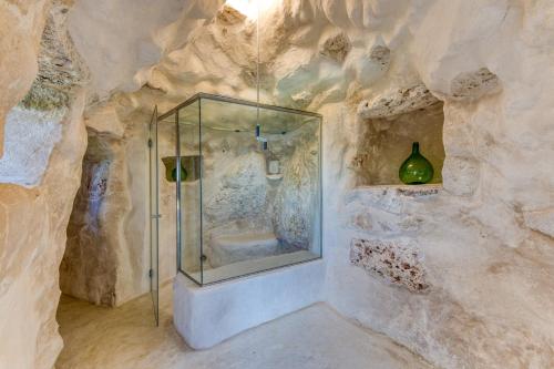 a bathroom with a shower in a rock wall at Tenuta Belvedere Luxury e Spa in Gagliano del Capo
