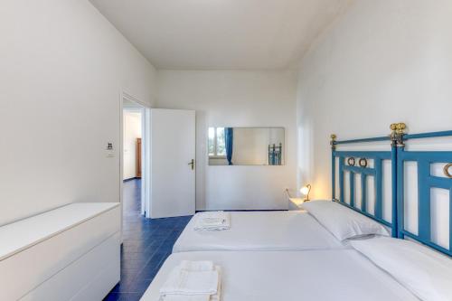 a bedroom with two white beds and a blue headboard at Tenuta Belvedere Luxury e Spa in Gagliano del Capo