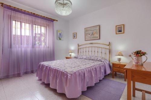 a bedroom with a bed with a purple bedspread at Apartamento villasol in Arona