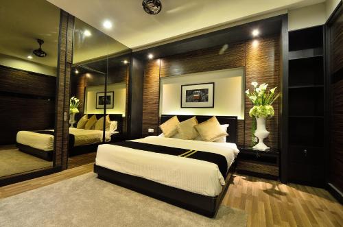Un dormitorio con una cama grande y un espejo. en Plumeria Luxury Service Villa, en George Town