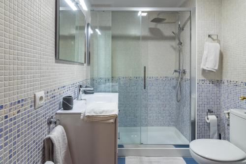 a bathroom with a shower and a sink and a toilet at Piso con piscina in Bádames