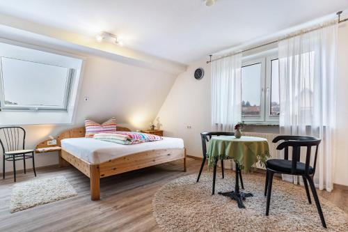 a bedroom with a bed and a table and chairs at Haus Ursula in Ettenheim