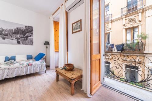 a room with a bed and a table and a window at Alla Marina Monolocale Deluxe in Cagliari