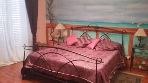 a bedroom with a pink bed with pink pillows at Bed and Breakfast sapore da mare in Lido di Ostia