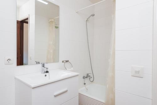 a white bathroom with a sink and a shower at Can Guixa in Sóller