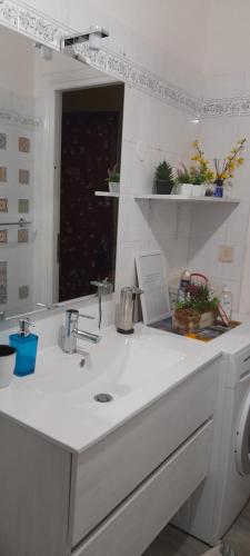 a white bathroom with a sink and a mirror at Bed and Breakfast sapore da mare in Lido di Ostia