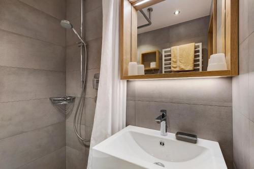 a bathroom with a sink and a shower and a mirror at Bed and Breakfast Ederhof in San Giacomo