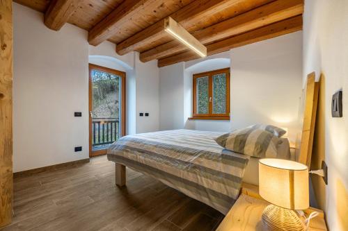 a bedroom with a bed and a balcony at Casa al Mulino 2 in Tenno