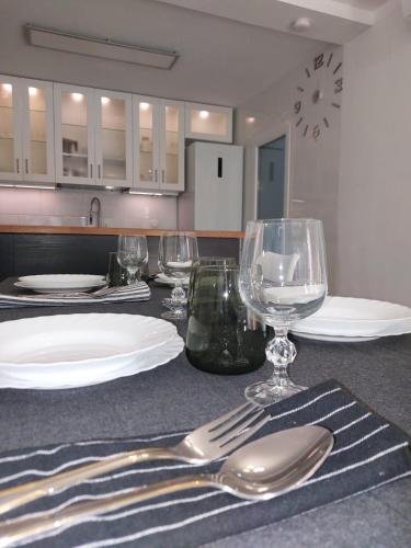 a table with plates and wine glasses on a counter at Bonito bungalow en la playa in Gran Alacant