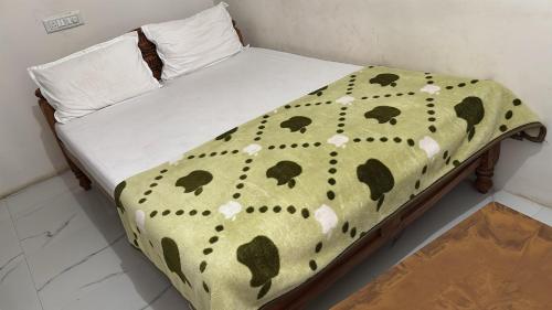 a bed with a polka dot blanket on it at Subhiksha Rooms in Bellūru